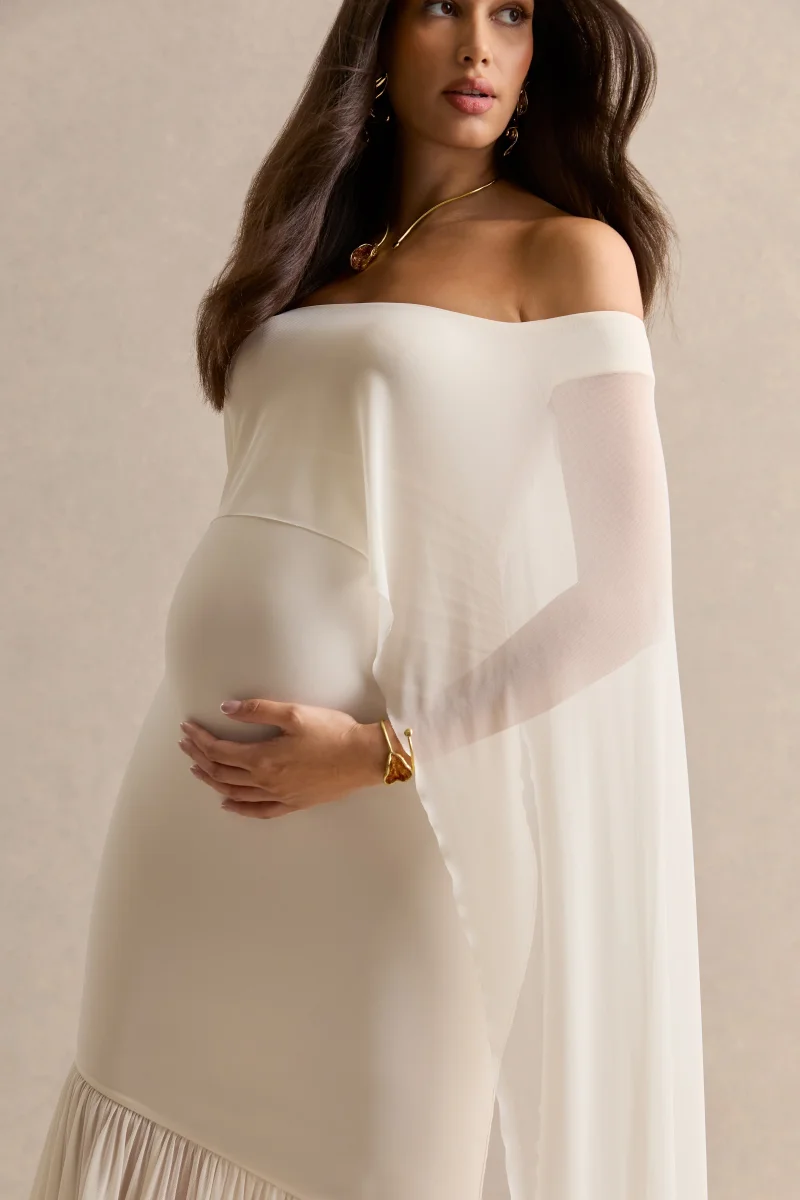 Bluma | Vestido Largo Premamá Crema Con Escote Bardot, Falda Semitransparente Y Detalle Capa - Imagen 7