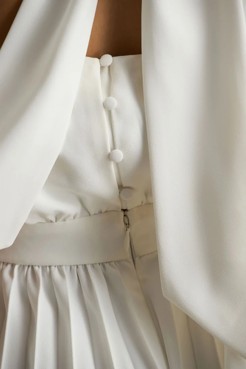 Paradise | Mono blanco con detalle de lazada en el cuello y manga tipo capa - Imagen 7